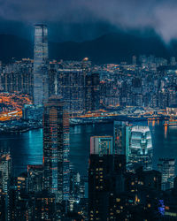 Illuminated buildings in city against sky at night