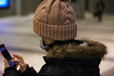 Side view of woman using mobile phone in winter