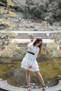 Full length of woman standing by tree