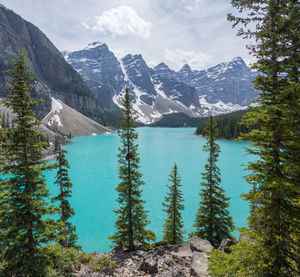 Scenic view of lake by mountains against sky
