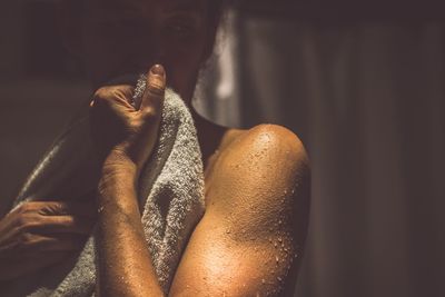 Thoughtful shirtless man holding towel in bathroom