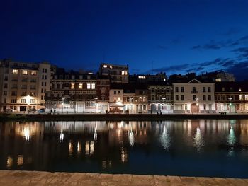 Reflection of buildings in lake at night