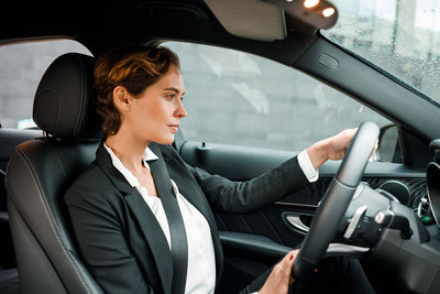 Side view of woman sitting in car