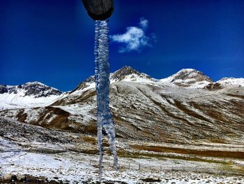 Scenic view of snowcapped mountains against blue sky