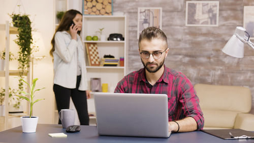 Young woman using laptop while sitting at office