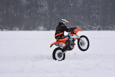 Man riding bicycle on snow
