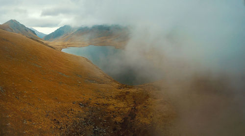 Smoke emitting from volcanic mountain against sky