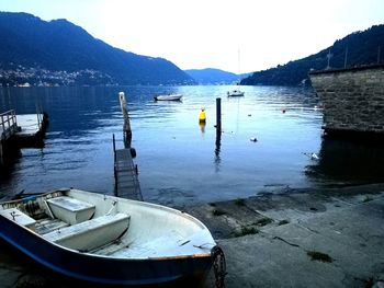 Boats moored in lake against sky