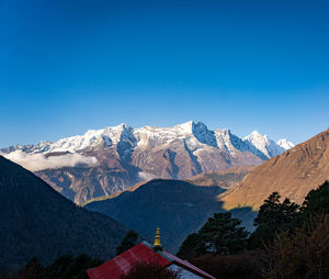 Scenic view of snowcapped mountains against clear blue sky