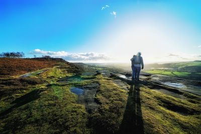 Couple standing on land against blue sky