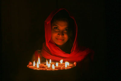 Portrait of mature woman against black background