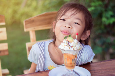 Portrait of cute girl having ice cream in restaurant