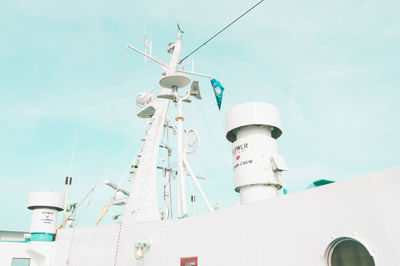 Low angle view of telephone pole by building against sky
