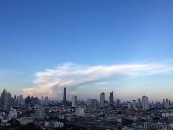 Modern buildings in city against blue sky