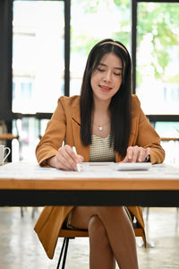 Young woman using laptop while sitting at cafe