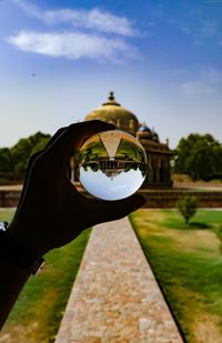 Person holding umbrella against sky
