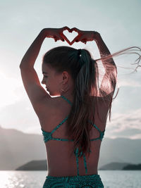 Portrait of young woman standing at beach