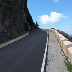 Surface level of road by mountain against sky