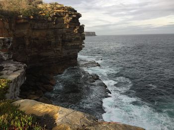 Scenic view of rocks in sea against sky