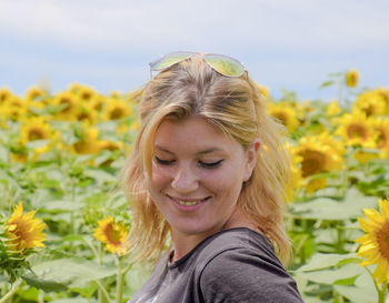 Woman standing against sunflowers field