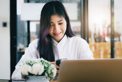 Portrait of young woman using phone