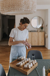 Woman checking spices at dining table