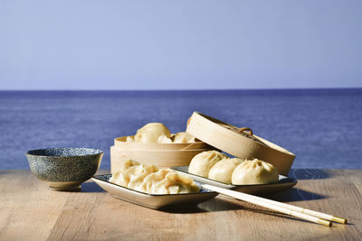 Close-up of food on table by sea against sky