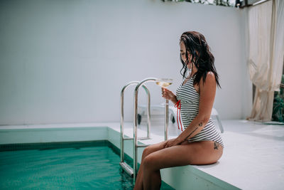 Woman sitting in swimming pool