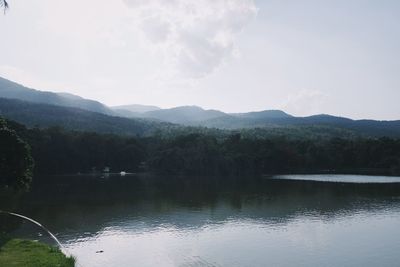 Scenic view of lake by mountains against sky