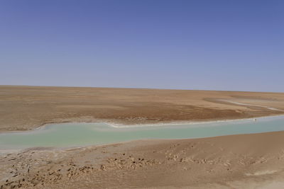 Scenic view of desert against clear blue sky