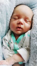 Close-up of baby boy sleeping on bed