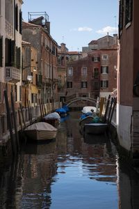 Boats moored in canal against buildings