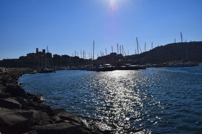 Sailboats in sea against clear blue sky