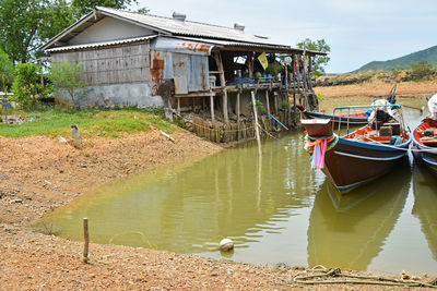 View of boats in river next to house