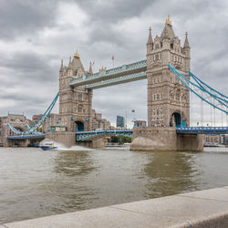 London bridge with a police boat speeding underneath