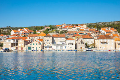 Buildings in town against clear blue sky