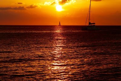 Boats in sea at sunset