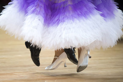 Low section of couple dancing on hardwood floor