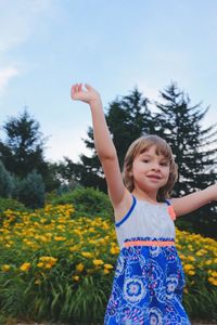 Portrait of happy girl on field against clear sky