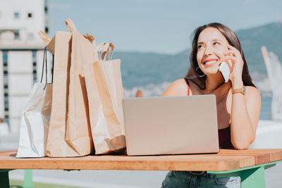 Happy woman talking on smart phone outdoors