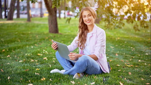 Portrait of smiling woman sitting on grass