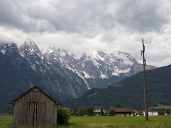 Built structure on snowcapped mountain against sky