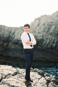 Portrait of young man standing on rock