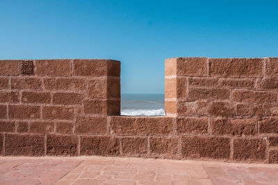 Brick wall against clear blue sky