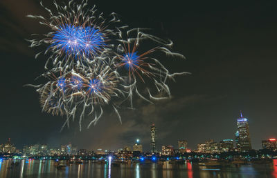 Firework display over illuminated buildings in city at night