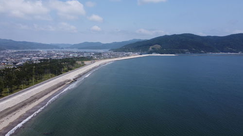 Scenic view of sea and mountains against sky