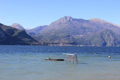 Scenic view of sea and mountains against clear sky