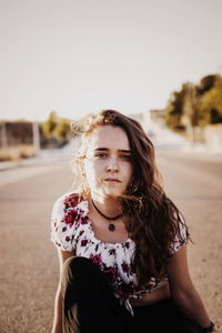 Portrait of young woman standing against sky