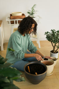 Side view of woman using mobile phone while sitting at home