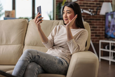 Woman having video call on mobile phone at home